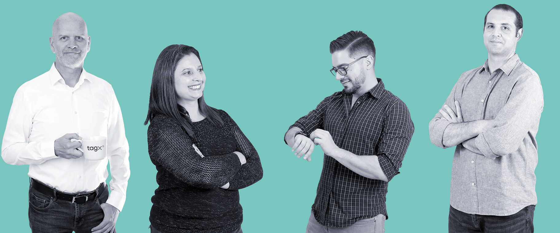 A group of four TAGx team members standing against a teal background. One person holds a TAGx-branded mug, another holds a laptop, and the others are engaged in conversation with arms crossed, creating a casual, collaborative atmosphere.